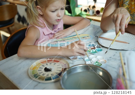 A young mother and her daughter enjoy a creative art session at home A young mother and her daughter enjoy a creative art session at home 128218145