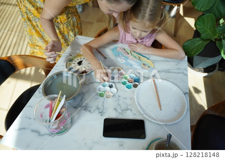 A young mother and her daughter enjoy a creative art session at home  128218148