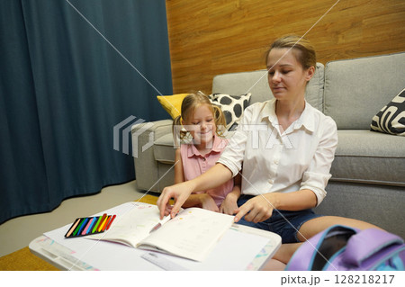 A mother supports her daughter with homework 128218217