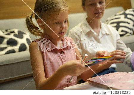 A mother supports her daughter with homework 128218220