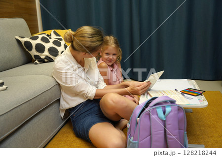 A mother supports her daughter with homework 128218244
