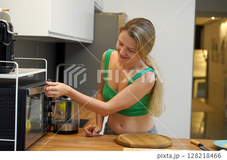 A young woman joyfully prepares a variety of healthy meals  128218466