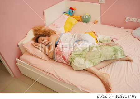 A young woman is enjoying a wonderfully serene morning in her bedroomnd A young woman is enjoying a wonderfully serene morning in her bedroomnd 128218468