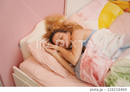 A young woman is enjoying a wonderfully serene morning in her bedroomnd A young woman is enjoying a wonderfully serene morning in her bedroomnd 128218469