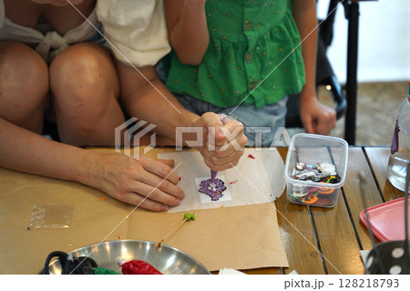 Mother and her daughter paint Halloween cookies  128218793