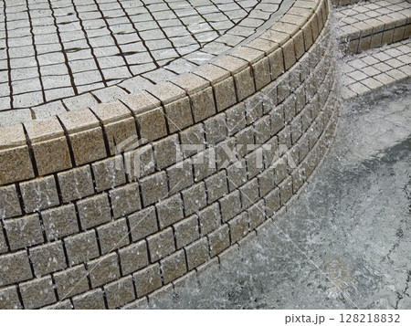 A beautiful fountain in the park is elegantly surrounded by stairs 128218832