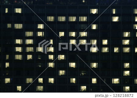 A tall building with many windows is beautifully lit up at night 128218872