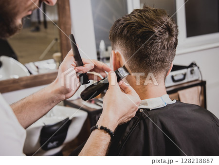 Young man with trendy haircut at barber shop. Young man with trendy haircut at barber shop. 128218887