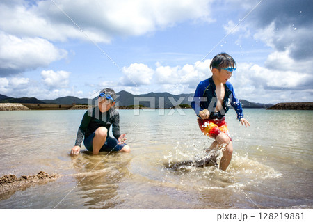 <素材>夏の海水浴場で遊ぶ子供たちと青空 <素材>夏の海水浴場で遊ぶ子供たちと青空 128219881