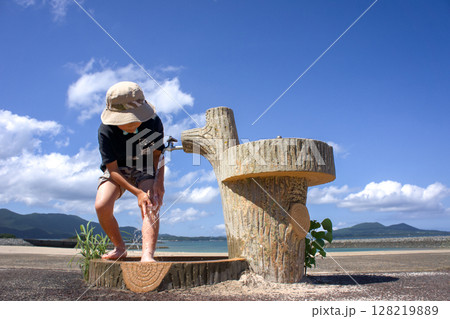 <素材>夏の海水浴場で足を洗う男の子 <素材>夏の海水浴場で足を洗う男の子 128219889