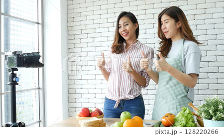 Asian influencer vlogger live review tomato skin care healthy eating lifestyle. Two Young Women Friends blogger vlog Happy Lifestyle vitamin C tomato vegetable fruit. Vlog Two women talk social media 128220266