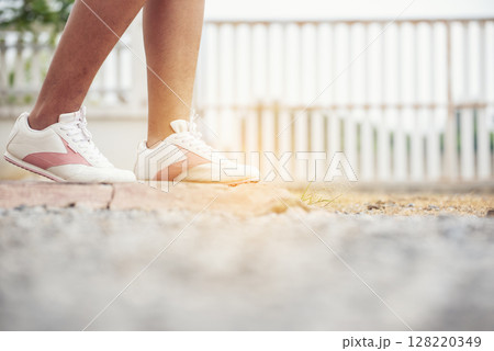 Sport sneakers footwear young woman knelt down do up shoelaces. Ready running shoes in sport exercise jogging person. Close up hands tie up runner shoelaces in fitness gym healthy person lifestyle. Sport sneakers footwear young woman knelt down do up shoelaces. Ready running shoes in sport exercise jogging person. Close up hands tie up runner shoelaces in fitness gym healthy person lifestyle. 128220349