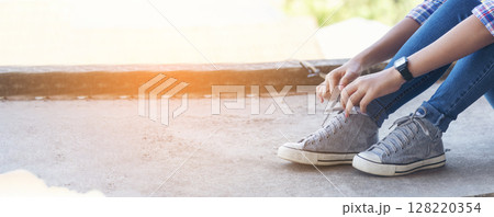sneaker shoes young woman traveler sit down on summer park. Focus on sneaker shoes and jeans on pathway in forest park. active activity vacation on hike mountain walking way. Young traveler concept sneaker shoes young woman traveler sit down on summer park. Focus on sneaker shoes and jeans on pathway in forest park. active activity vacation on hike mountain walking way. Young traveler concept 128220354