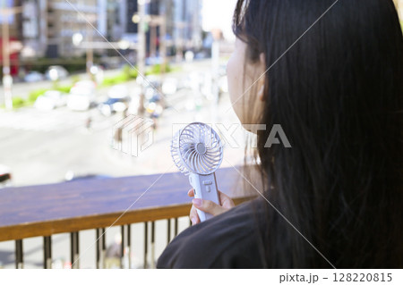 ハンディファンを使う女性 ハンディファンを使う女性 128220815