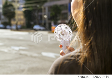 ハンディファンを使う女性 128220819