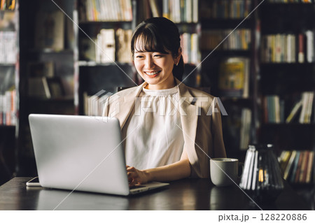 書斎,図書館でノートパソコンを使って仕事する若いアジア人ビジネスウーマン 書斎,図書館でノートパソコンを使って仕事する若いアジア人ビジネスウーマン 128220886