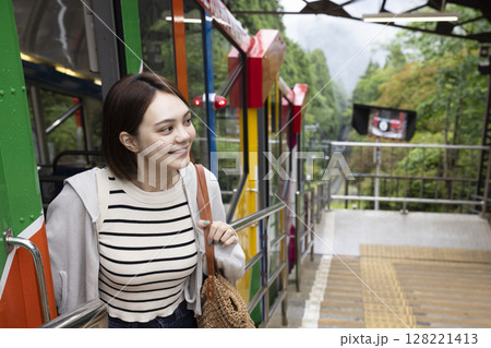 ケーブルカーに乗り国内旅行を楽しむ女性 128221413