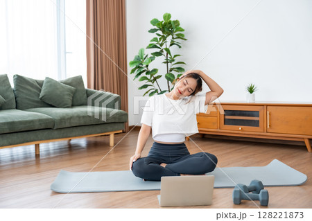 Young Asian woman stretching yoga workout on exercise mat 128221873