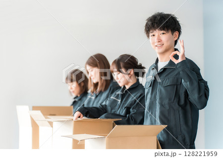 ダンボールに梱包作業をする運送・物流・宅急便・宅配便・流通・配達・倉庫・宅配業者の作業員の男女 128221959