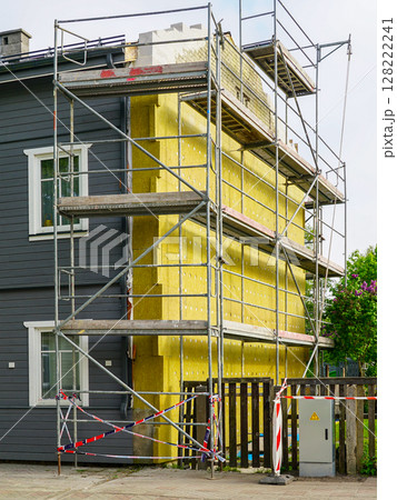 Scaffolding and Thermal Insulation Installation on a Residential House Exterior Wall 128222241