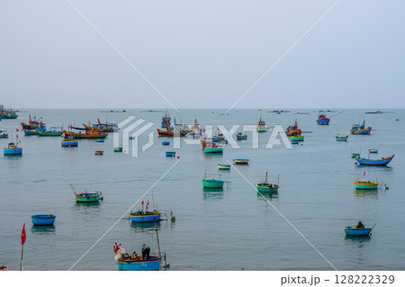 Traditional Boats and Basket Vessels Drifting on the Calm Sea of Mui Ne, Vietnam Traditional Boats and Basket Vessels Drifting on the Calm Sea of Mui Ne, Vietnam 128222329