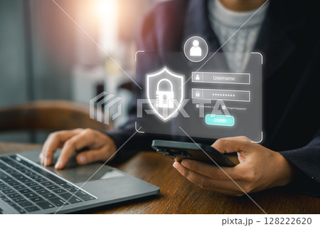 A person accessing a secure login interface on a laptop and smartphone, highlighting online security and digital authentication. A person accessing a secure login interface on a laptop and smartphone, highlighting online security and digital authentication. 128222620