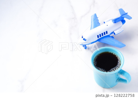 離陸を待つ旅客機と、淹れたてのコーヒーで、コーヒーを飲みながら旅行を計画しているイメージ 128222758