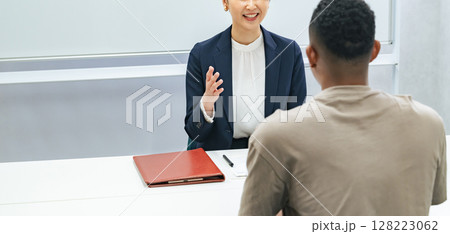 黒人男性と面談する日本人女性スタッフ 黒人男性と面談する日本人女性スタッフ 128223062