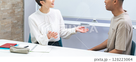 教室で会話する黒人男性と日本人女性 教室で会話する黒人男性と日本人女性 128223064