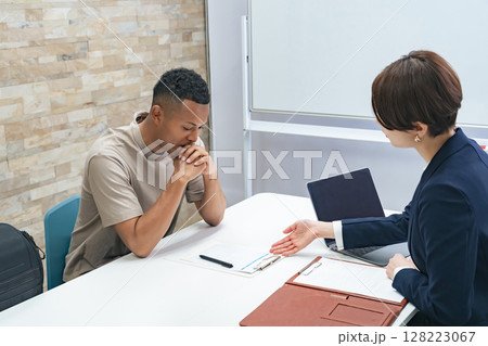 面談する黒人男性と日本人女性スタッフ 128223067