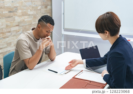 面談する黒人男性と日本人女性スタッフ 面談する黒人男性と日本人女性スタッフ 128223068