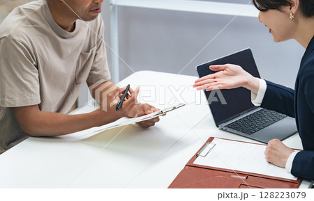 面談する黒人男性と日本人女性スタッフ 128223079