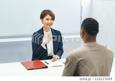 黒人男性と面談する日本人女性スタッフ 128223089
