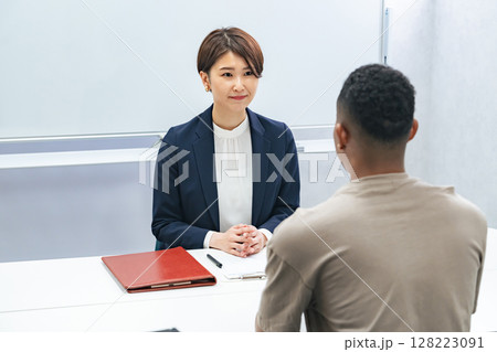 黒人男性と面談する日本人女性スタッフ 128223091