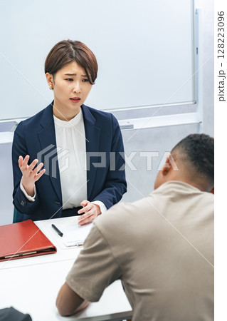 悩む黒人男性と面談する日本人女性スタッフ 悩む黒人男性と面談する日本人女性スタッフ 128223096