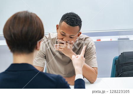 悩む黒人男性と面談する日本人女性スタッフ 128223105