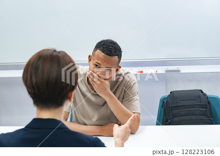 悩む黒人男性と面談する日本人女性スタッフ 128223106
