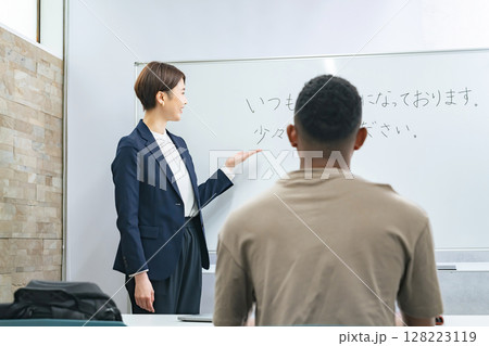 黒人男性に日本語学校でビジネス用語を教える女性教師 128223119