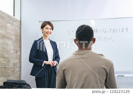 黒人男性に日本語学校でビジネス用語を教える女性教師 128223120