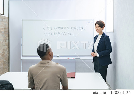 黒人男性に日本語学校でビジネス用語を教える女性教師 128223124