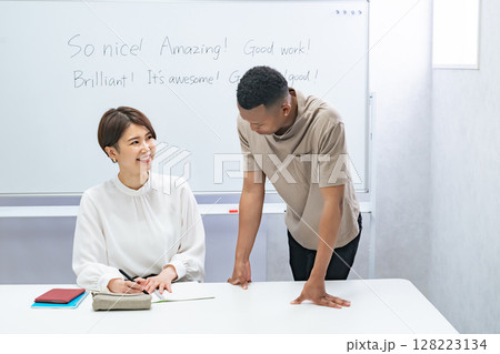 教室で会話する黒人男性と日本人女性 128223134