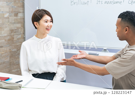 教室で会話する黒人男性と日本人女性 128223147