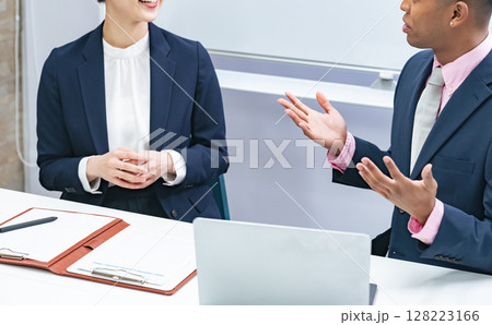 黒人男性ビジネスマンと面談する日本人女性スタッフ 128223166