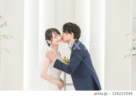 結婚式で誓いのキスをする新郎新婦(頬) 128223344