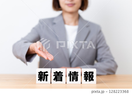 新着情報のブロックとスーツを着たミドル女性ビジネスウーマン 新着情報のブロックとスーツを着たミドル女性ビジネスウーマン 128223368