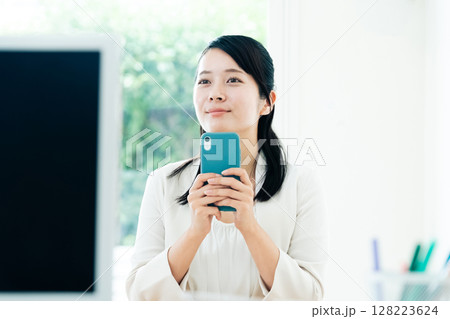 スマホで動画を見るビジネスウーマン スマホで動画を見るビジネスウーマン 128223624