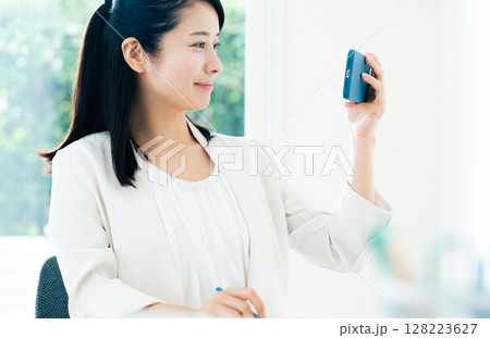 スマホで動画を見るビジネスウーマン 128223627