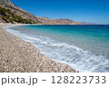 Turquoise sea gently lapping on the pebbly shore of Apella beach on Karpathos island 128223733