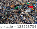Plastic bottles and garbage polluting a pebble beach 128223734