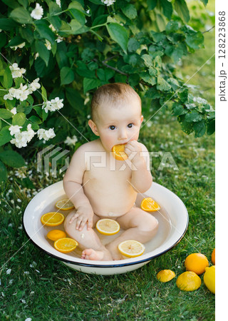 Baby Sitting In Bowl With Citrus Slices Outdoors 128223868